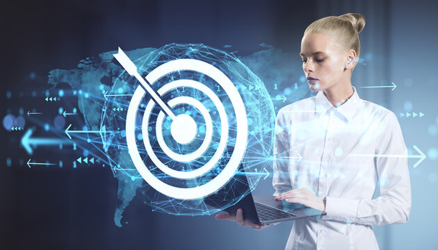 Businesswoman using laptop with target icon and global network interface on digital abstract background representing success and online strategy.