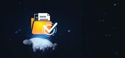 Digital file folder with checkmark icon floating above open hand on dark tech background, representing data approval and document verification concept.