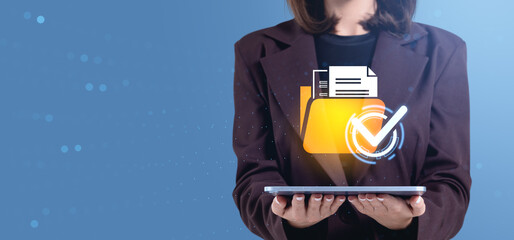 Businesswoman holding tablet with digital folder and checkmark icon representing document verification concept on blue background.
