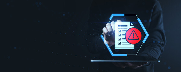 Cybersecurity warning concept showing checklist with alert icon on futuristic interface held above tablet on dark digital background.