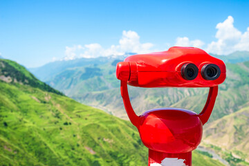 Red binoculars overlooking a mountain canyon. North Caucasus