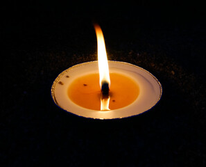 burning candle on black background