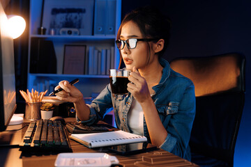 Creating young beautiful Asian creative woman thinking of sales target report on business market graph folder paperwork report, looking out of indoor with holding pen at neon at night time. Stratagem.