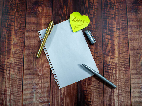Blank note love heart pen on rustic wood background. Romance and copy space.