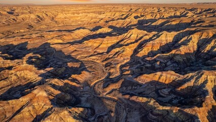 Aerial view of a dry canyon landscape with winding riverbed at sunset in arid environment region