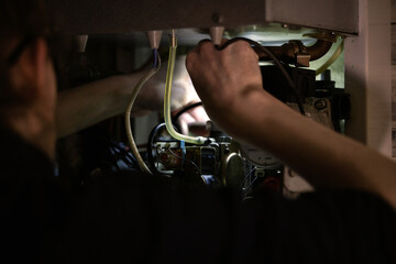 The repairman fixes the heating system. Boiler repair.