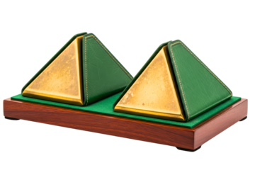 Two golden metal pyramids mounted on a wooden base with green trim isolated on transparent background