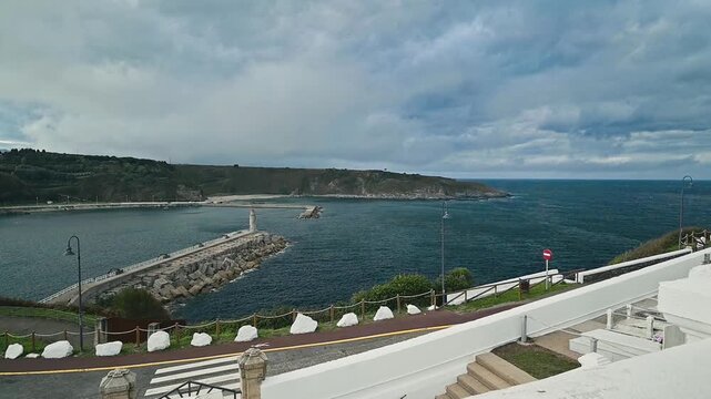 Dramatic cloudy sky over the Luarca harbor in an slow motion zoom out day scene.