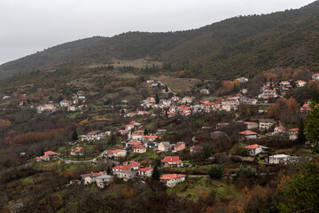 View of the village (Greece, Epirus) and snow-covered mountains in a winter on a cloudy day