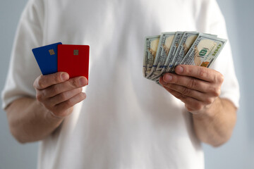 Man holds dollar bills and credit card close-up