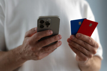 Man's hands hold smartphone and credit cards close-up