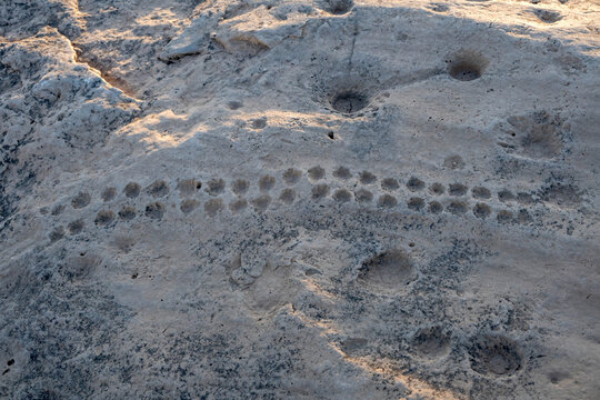 Doha, Qatar - November 05, 2025: Rock outcrop with ancient dot carvings at Jebel al Jassasiya site in Northern Qatar.