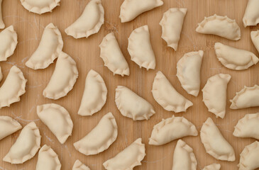 Lots of handmade dumplings on a pastry board, top view, polish pierogi
