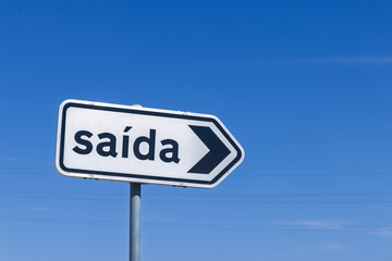 A white rectangular road sign in Portugal with the word "sa&iacute;da," meaning exit.