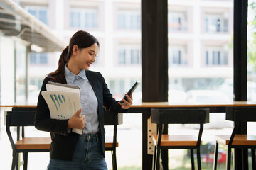 Asian businesswoman reading business messages on smartphone
