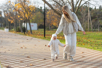 Obraz premium A beautiful woman walks in the park with a child 