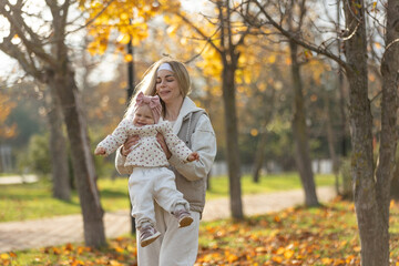 A beautiful woman walks in the park with a child 