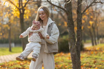 A beautiful woman walks in the park with a child 