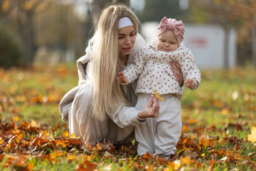 A beautiful woman walks in the park with a child 
