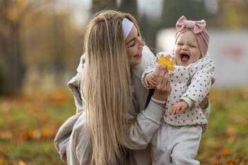 A beautiful woman walks in the park with a child 