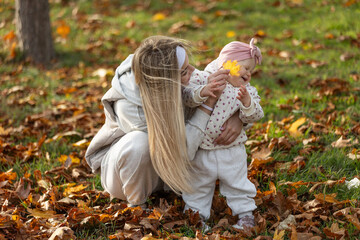 A beautiful woman walks in the park with a child 