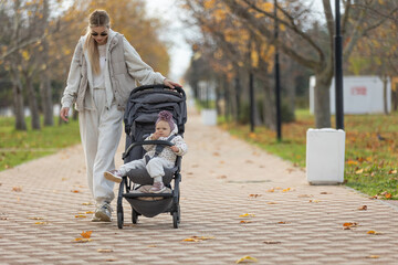 A beautiful woman walks in the park with a child 