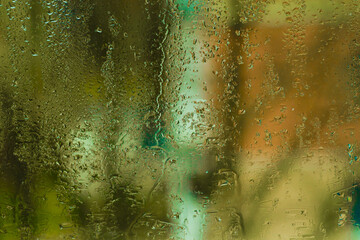 Water drops on glass surface form intricate patterns, textured background. ideal for design and creative. background of wet glass, water droplets forming beautiful abstract patterns. green backdrop.