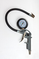 Professional tire pressure gauge and inflator gun with a hose, displayed on a clean white background. Essential tool concept for automotive repair, car service, and garage equipment demonstration, emp