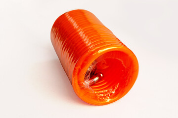 Bright orange coiled air compressor hose in a new, packaged roll on a white background, showing...