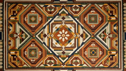 An intricate mosaic floor design features repeating geometric patterns in earthy tones, creating a sense of historical artistry and craftsmanship with symmetrical square and octagonal shapes