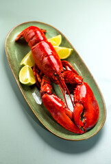 Lobster on plate, Lobster seafood, gourmet food, steamed lobster with big claws on a plate with lemon, top view, flat lay, from above. Vertical banner art design, close-up
