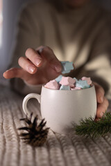 finger reaching for star marshmallow in oversized ceramic mug, content creator styling cozy flatlay, sweater