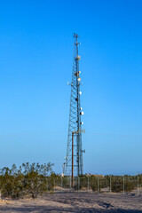 overland line in desert  area with huge mast carrying dishes and antenna