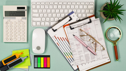 Business and accounting supplies arranged in a composition on an office desk. Top view.