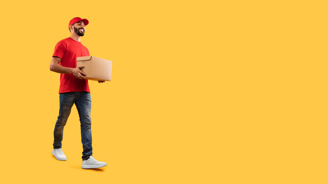 A cheerful delivery person in a red shirt and cap walks confidently while carrying a cardboard box. The bright yellow background enhances the vibrant atmosphere.