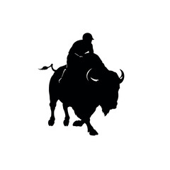 Silhouette of a person riding a buffalo.