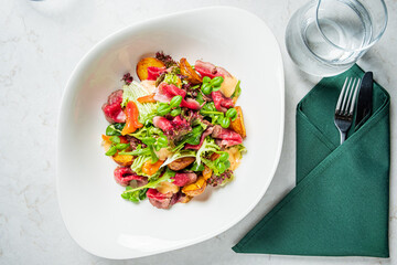 A vibrant salad with crispy greens, roasted veggies, and tender meat, ideal for a light meal