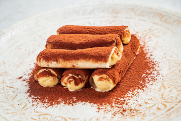 Layers of creamy tiramisu on an ornate plate invite dessert lovers to indulge