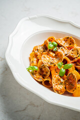 A vibrant bowl of pasta with clams is garnished with fresh herbs, showcasing culinary artistry