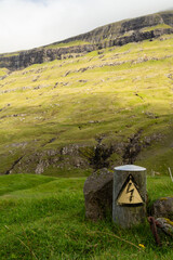 Electricity warning sign with mountains in the background.