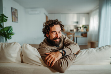 Obraz premium Smiling man relaxing on a sofa at home