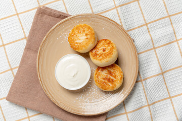 Freshly made breakfast pastries sit on a plate beside a small cup of smooth dip, inviting taste