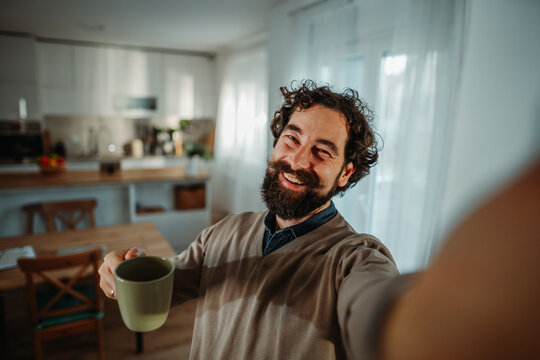Happy man taking selfie and enjoying morning coffee