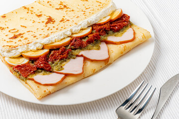 Enjoy a tasty crepe filled with tender chicken, sun-dried tomatoes, and herbs