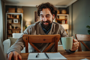 Man drinking coffee working from home remotely