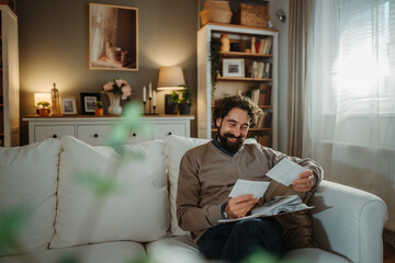 Happy man reliving memories looking at old photos