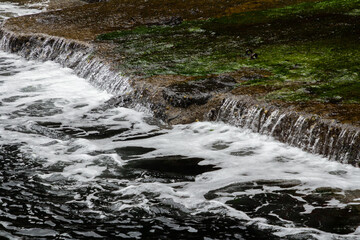 Clear water stream flowing through Gjógv harbor.