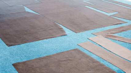 Pieces of cut fabric on a cutting table in a textile clothing factory.