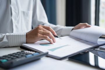 Professional Reviewing Business Data and Using Calculator.