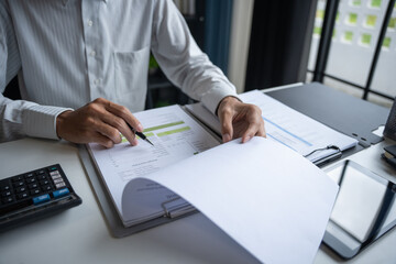 Professional Reviewing Business Data and Using Calculator.